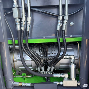 Hydraulic power unit with silver motor housing, braided hydraulic lines, and chrome fittings mounted to a green internal panel